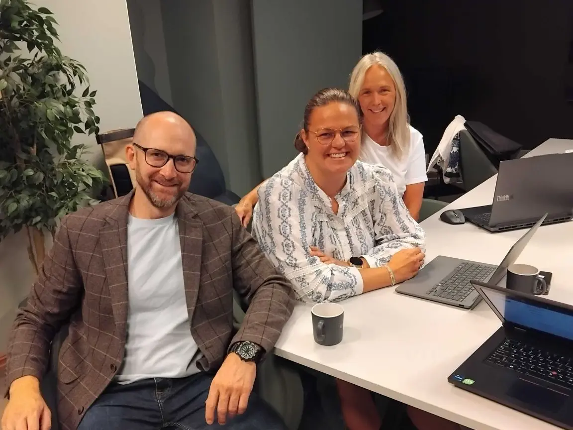 Mats Evensen sitter ved et bord med to kvinner fra Go'nok, med bærbare PC-er foran seg