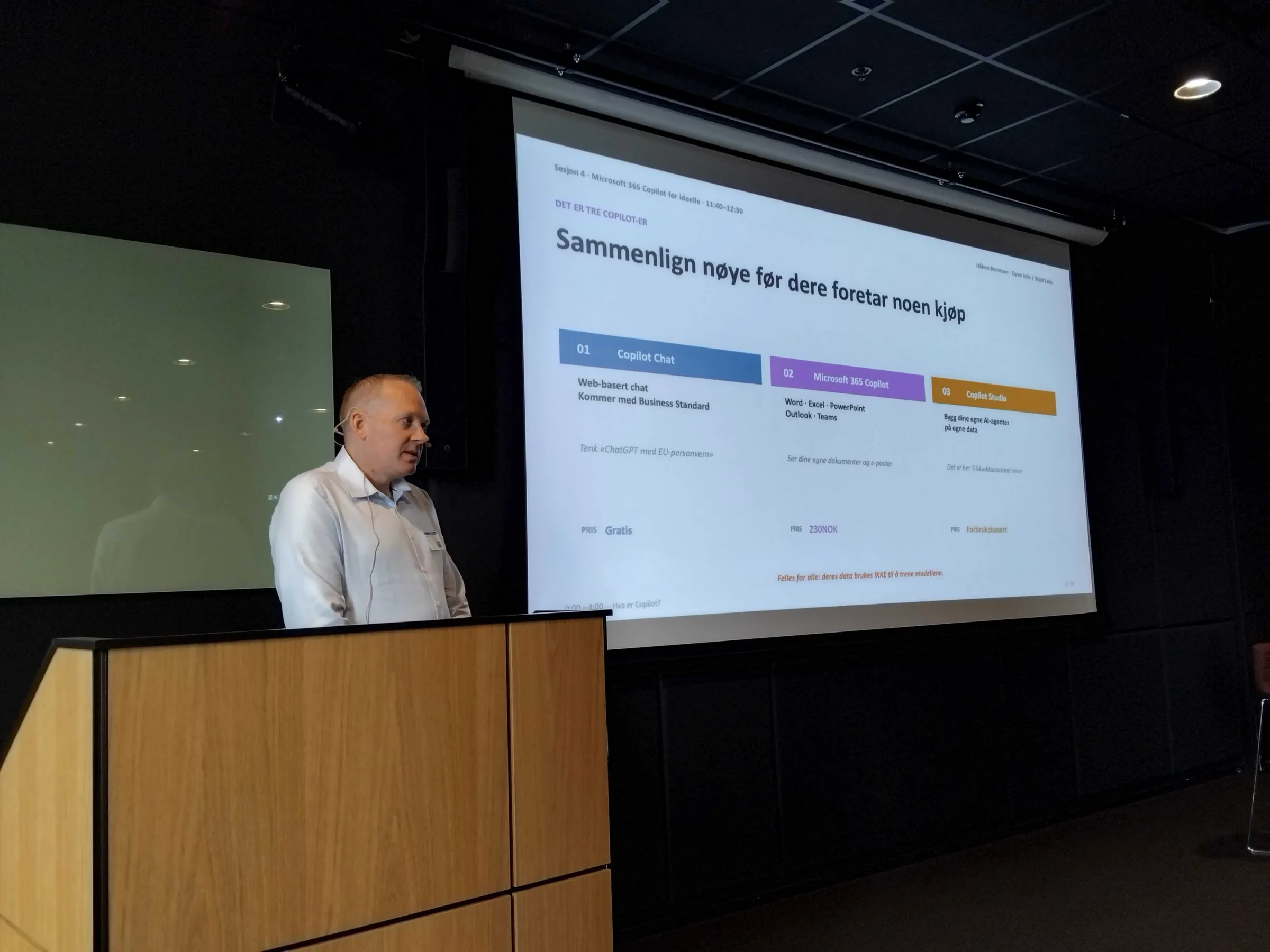 Håkon Berntsen ved talerstolen på fagdagen hos Microsoft, foran et lysbilde som sammenligner tre Copilot-varianter